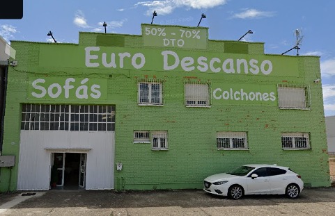 Fachada verde de la fábrica Euro Descanso en Viana